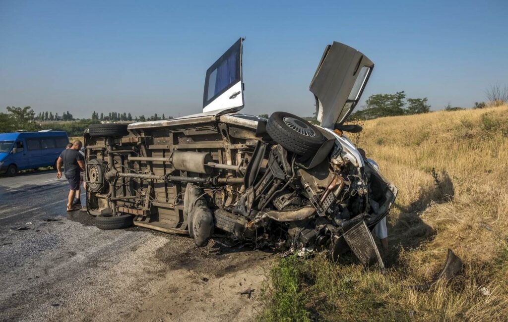 Bus overturned on the road after a crash during the day