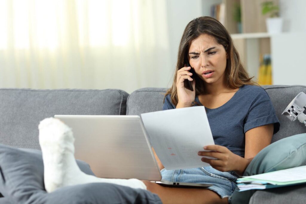 Accident victim looking at medical bills on the couch - Nevada damage caps can sometimes limit how much a plaintiff can recover
