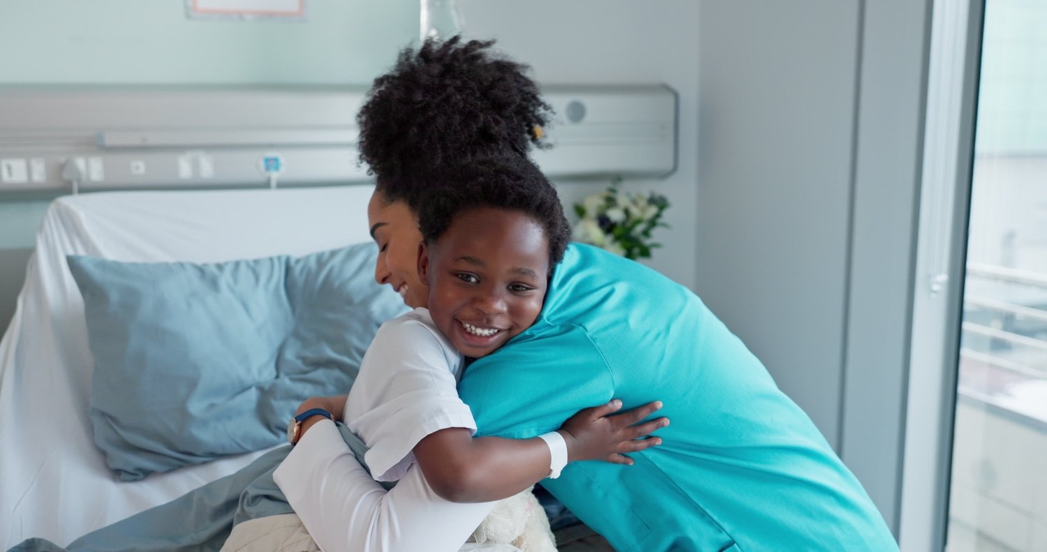 Nurse hugging a child in a hospital