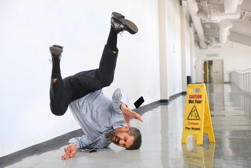 Man slipping on wet floor - Nevada slip and fall law allows some victims to sue for damages