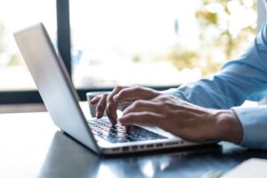 Man's hands typing at laptop