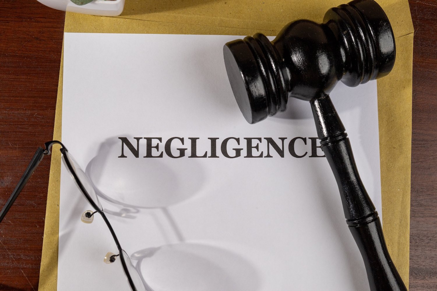Judge's gavel sitting atop a piece of paper spelling out "NEGLIGENCE" 