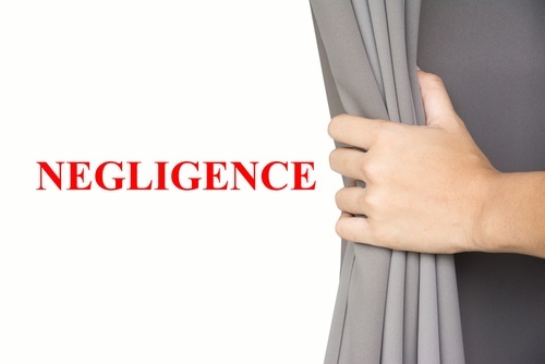 hand holding back curtain to white wall that says "negligence"
