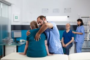 Medical care provider helping spinal injury victim in hospital room