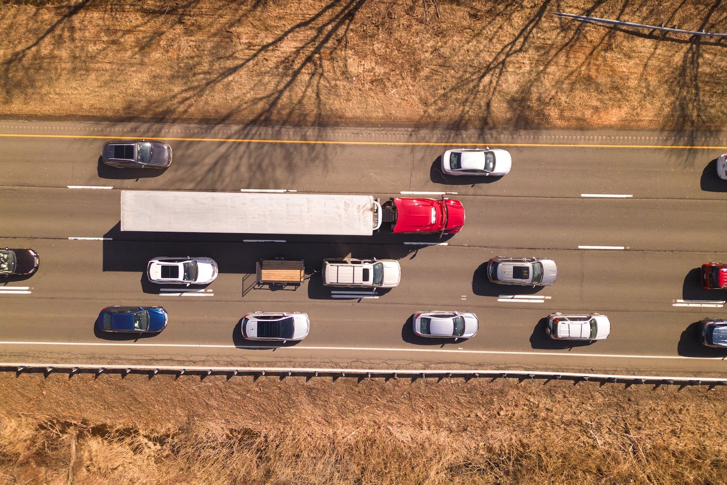 Overhead view of highway with big rig and several sedans