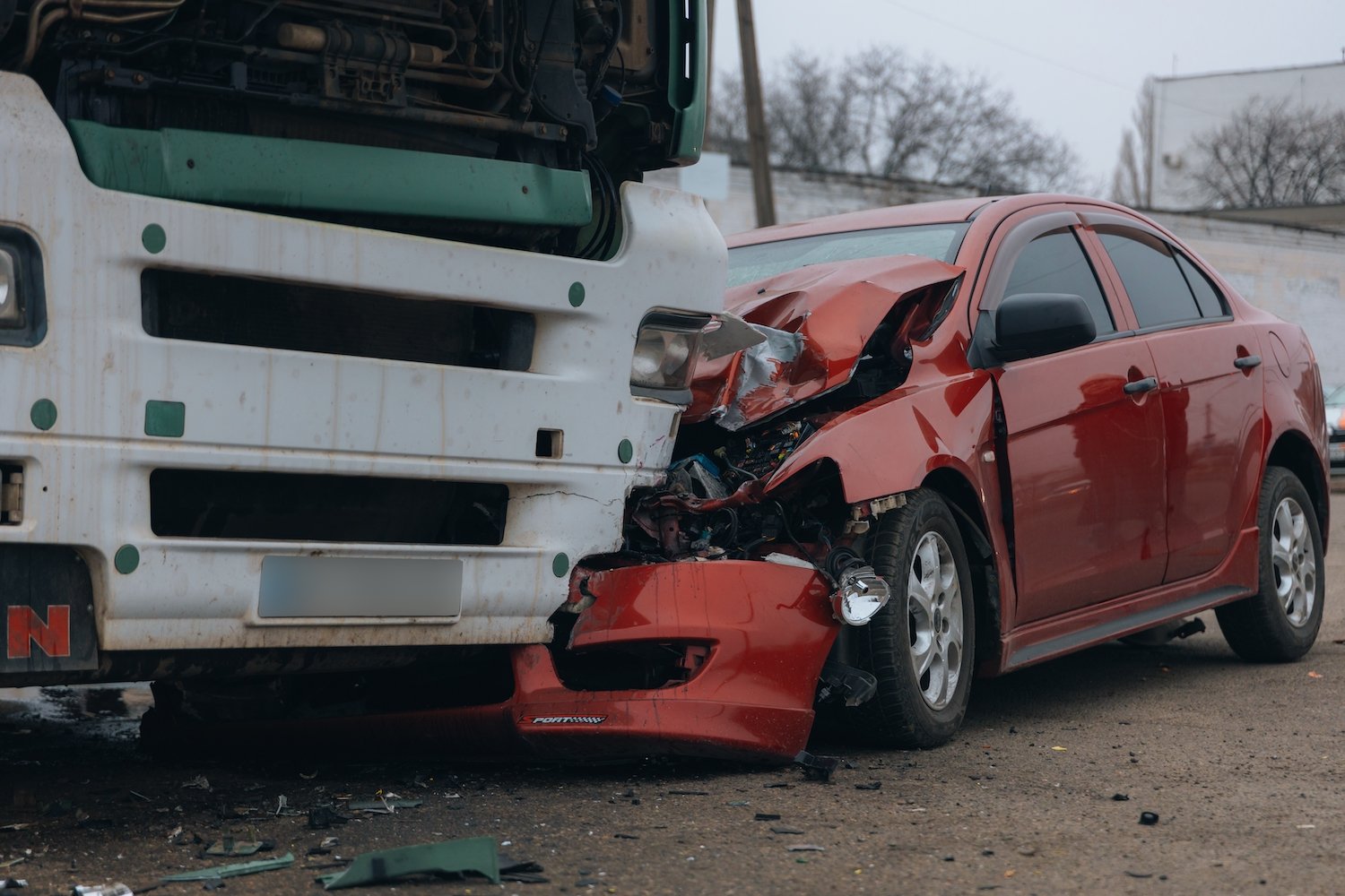 Aftermath of truck front-ending a red sedan on a cloudy day